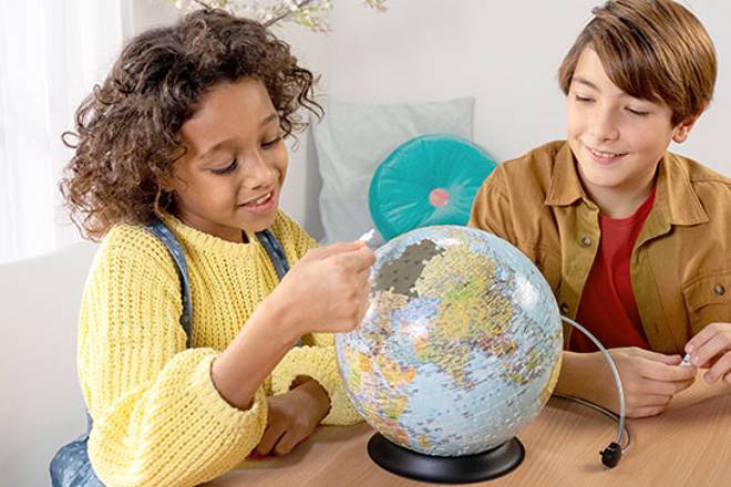 Fille et garçon avec un puzzle 3D Globe terrestre